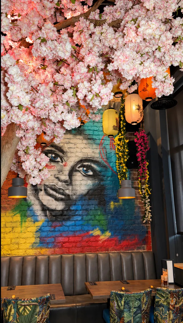 Blossom canopy over the booths, beside the face mural